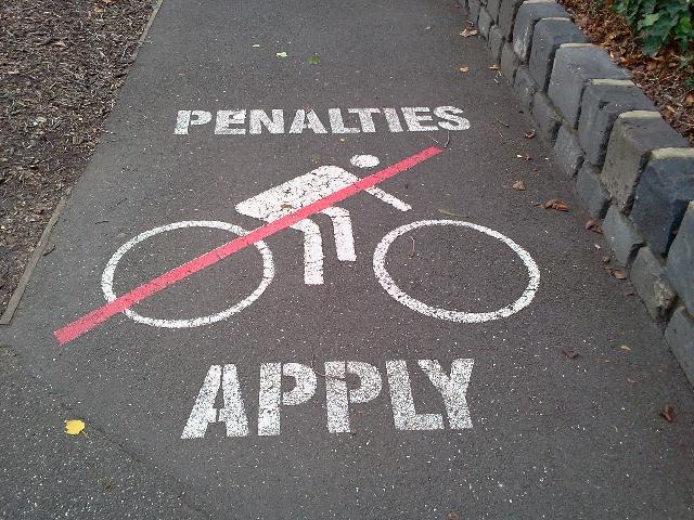 Bicycle warning sign: 'Penalties Apply'
